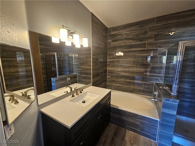 bathroom featuring vanity, independent shower and bath, and tile walls