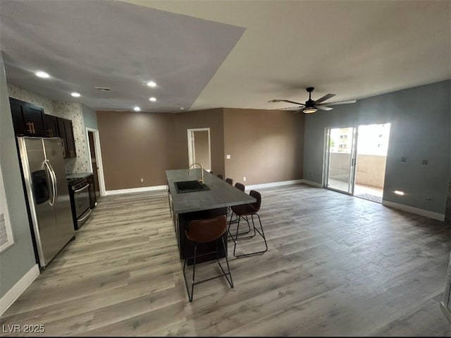 kitchen with light wood finished floors, a ceiling fan, stainless steel appliances, baseboards, and recessed lighting