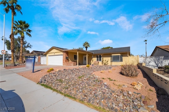 single story home with an attached garage, driveway, fence, and stucco siding