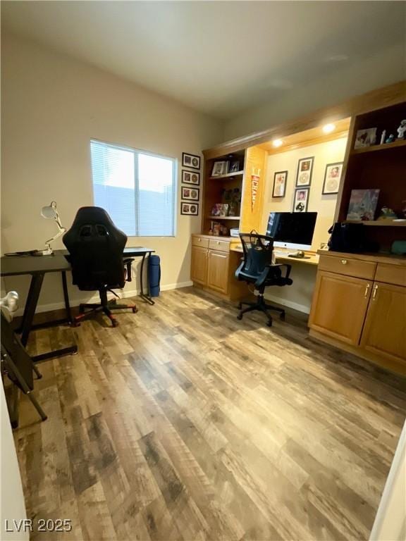 home office featuring built in desk and light wood-type flooring