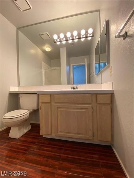 bathroom with vanity, toilet, an enclosed shower, and hardwood / wood-style floors