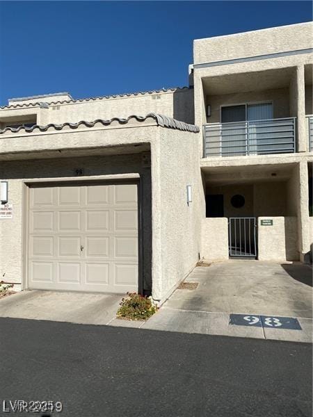 view of front of home featuring a garage and a balcony