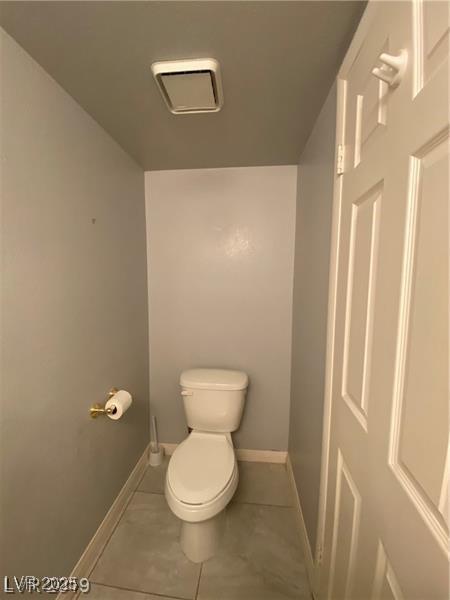 bathroom with toilet and tile patterned flooring