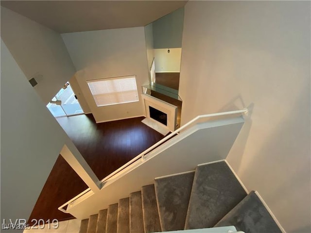 staircase featuring hardwood / wood-style floors and a high ceiling