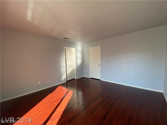 empty room with dark hardwood / wood-style floors