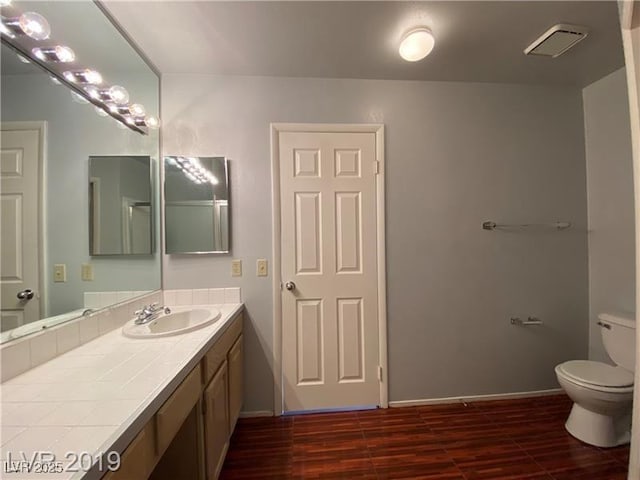 bathroom with hardwood / wood-style flooring, vanity, and toilet