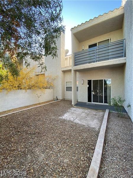 rear view of property with a balcony and a patio