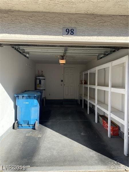 garage with strapped water heater and a garage door opener