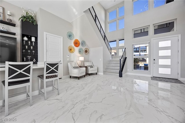 entryway featuring a towering ceiling and a wealth of natural light