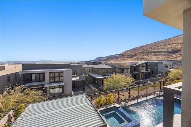 exterior space with a mountain view and an in ground hot tub