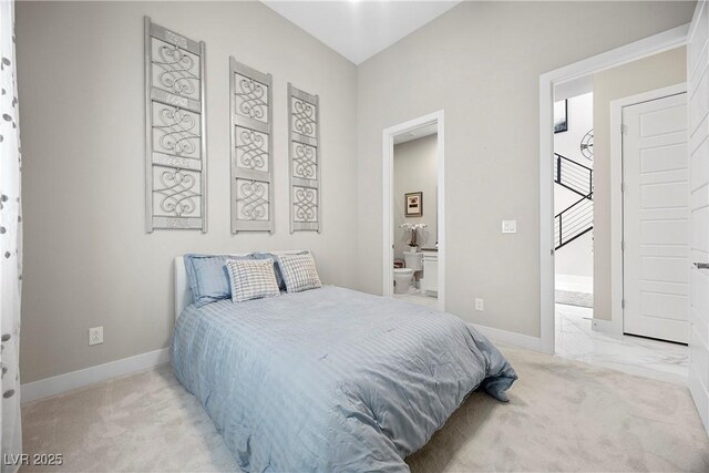 bedroom with connected bathroom and light colored carpet