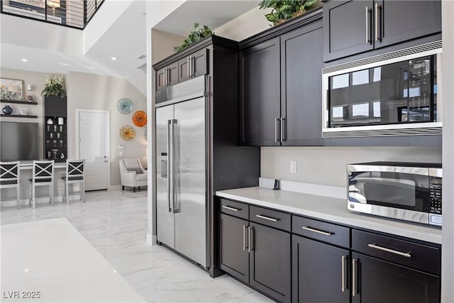 kitchen featuring built in appliances and lofted ceiling