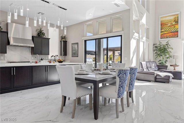 dining space featuring a towering ceiling