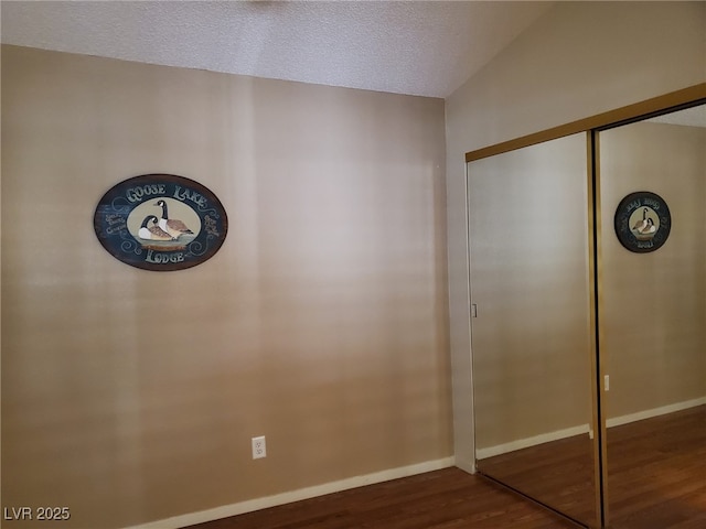 unfurnished bedroom featuring wood-type flooring, a closet, and a textured ceiling