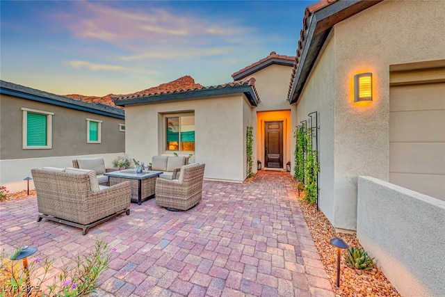 patio terrace at dusk featuring an outdoor living space