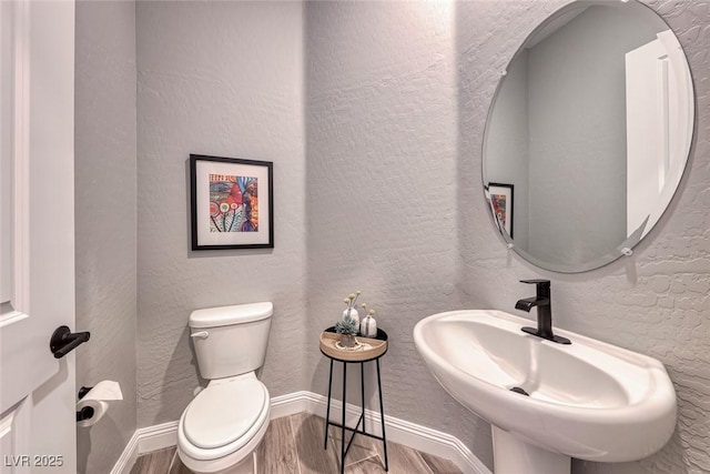 bathroom featuring hardwood / wood-style flooring, toilet, and sink