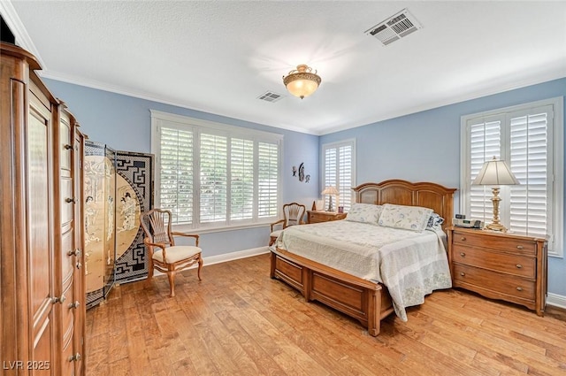 bedroom with ornamental molding and light wood-type flooring