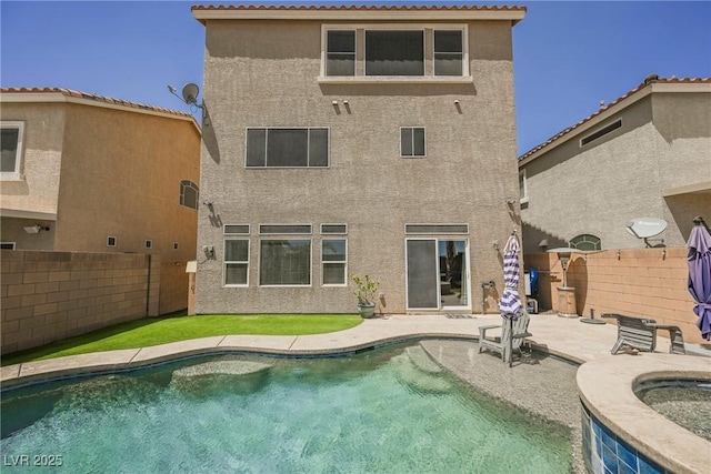 rear view of house with a fenced in pool and a patio area