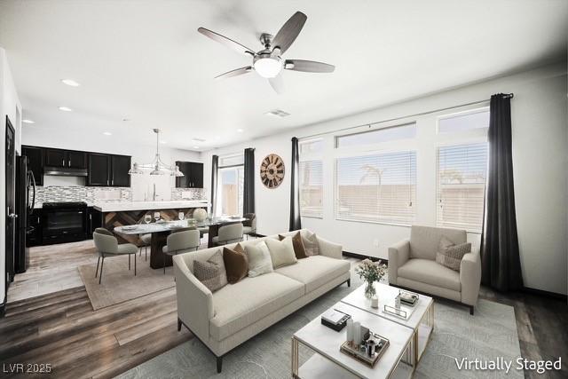 living room with hardwood / wood-style flooring and ceiling fan