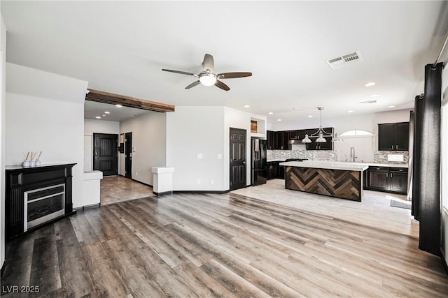 living room featuring sink, hardwood / wood-style flooring, and ceiling fan