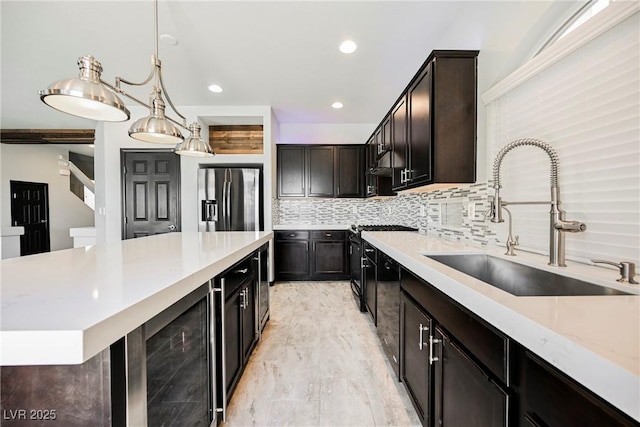 kitchen with sink, stainless steel fridge, pendant lighting, beverage cooler, and decorative backsplash