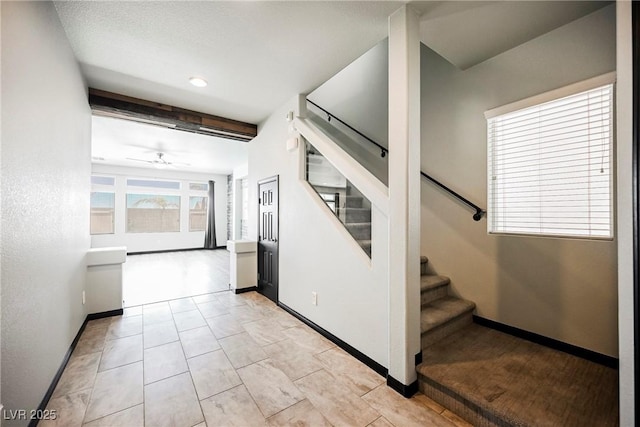 stairway featuring ceiling fan