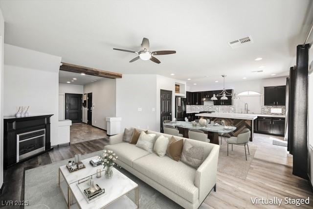 living room featuring light hardwood / wood-style floors and ceiling fan