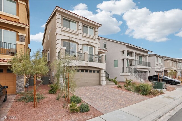 view of property featuring central AC unit and a garage