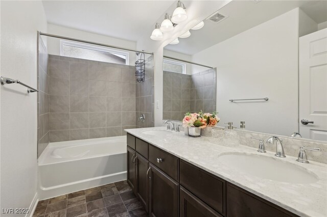 bathroom featuring tiled shower / bath and vanity