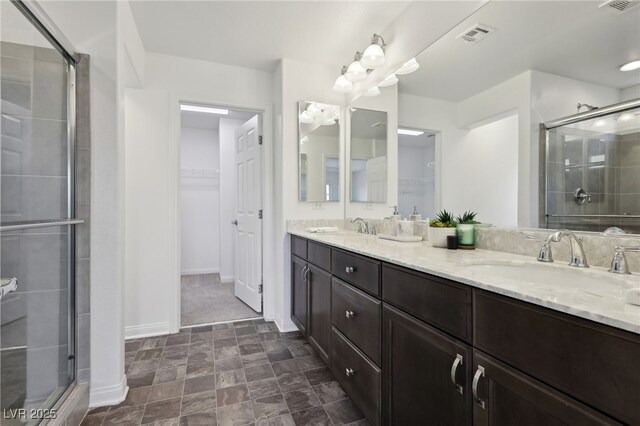 bathroom featuring a shower with door and vanity