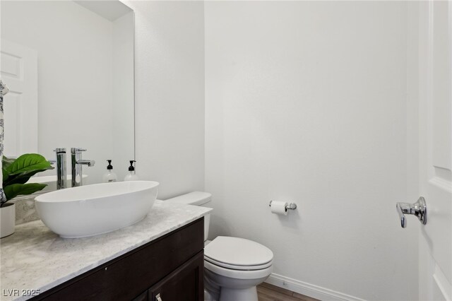 bathroom with vanity, hardwood / wood-style floors, and toilet