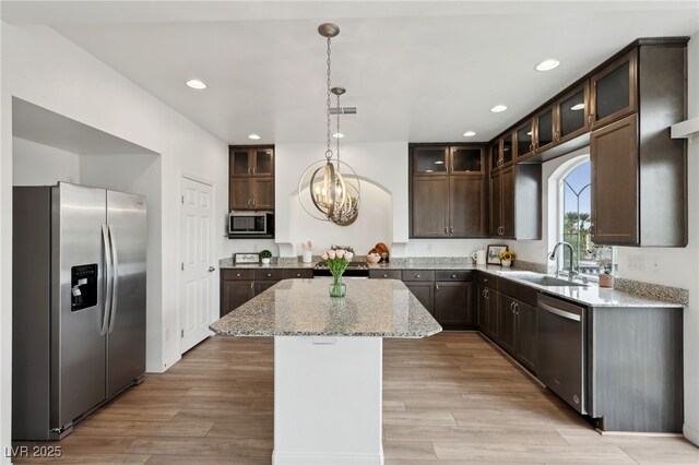 kitchen with a kitchen island, appliances with stainless steel finishes, sink, and dark brown cabinets