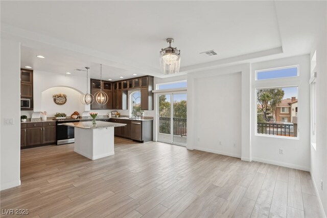 kitchen featuring a kitchen island, a chandelier, and dark brown cabinets