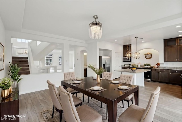 dining space with a chandelier and light hardwood / wood-style floors