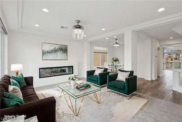 living room featuring wood-type flooring and ornamental molding