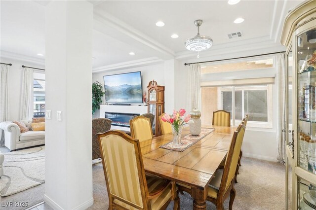 carpeted dining area featuring crown molding