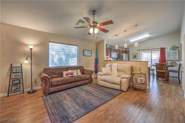 living room with wood-type flooring, vaulted ceiling, and ceiling fan