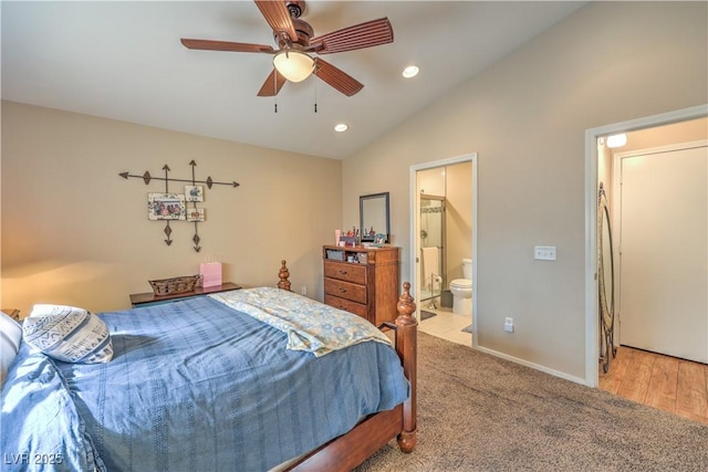 carpeted bedroom with ceiling fan, lofted ceiling, and ensuite bathroom