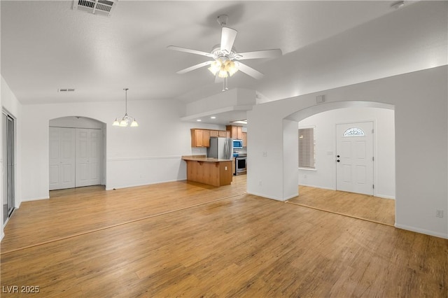 unfurnished living room with ceiling fan, lofted ceiling, and light wood-type flooring