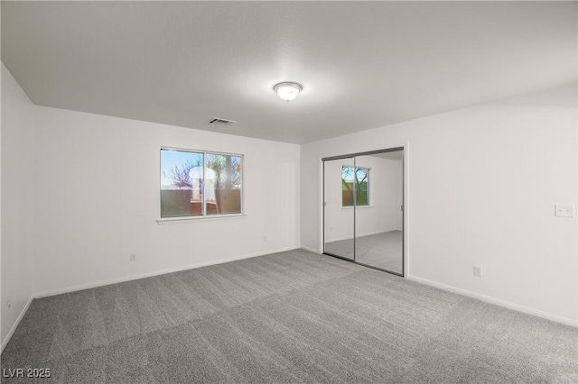 unfurnished room featuring a healthy amount of sunlight and carpet flooring