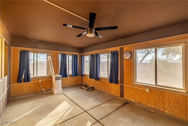 unfurnished sunroom featuring ceiling fan