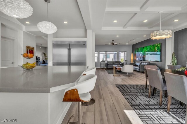 dining space with wood tiled floor, beam ceiling, coffered ceiling, and recessed lighting