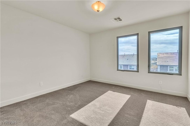 empty room featuring carpet floors, baseboards, and visible vents