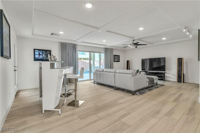 living area with light wood finished floors, coffered ceiling, visible vents, and a ceiling fan