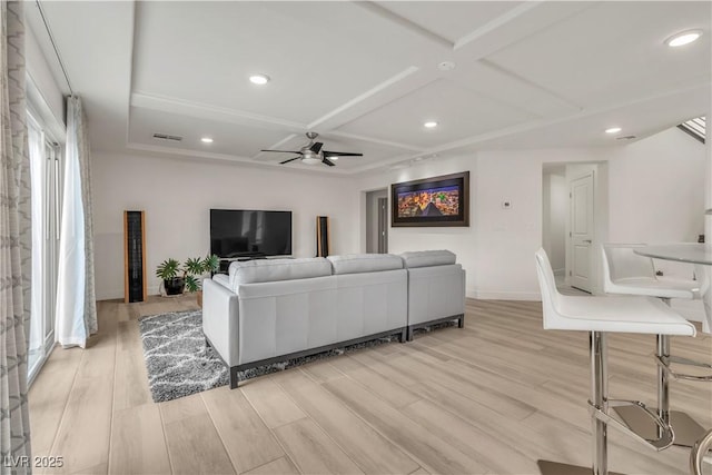 living room featuring ceiling fan, coffered ceiling, and light wood-type flooring