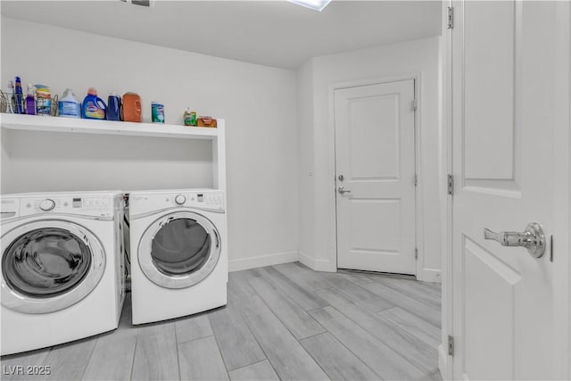 laundry area with wood finish floors, laundry area, washer and clothes dryer, and baseboards