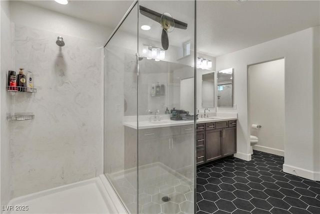 bathroom featuring vanity, a tile shower, and toilet