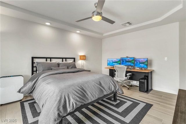 bedroom with recessed lighting, a raised ceiling, visible vents, ceiling fan, and light wood-type flooring