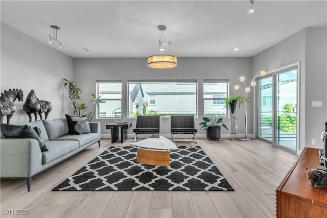 living room featuring baseboards, wood finished floors, visible vents, and rail lighting