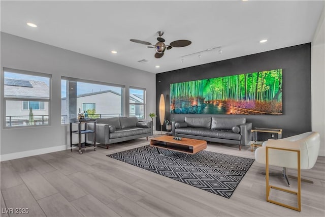 home theater room featuring ceiling fan, track lighting, and light wood-type flooring